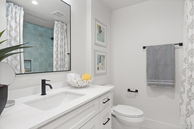 bathroom featuring toilet, vanity, curtained shower, and visible vents