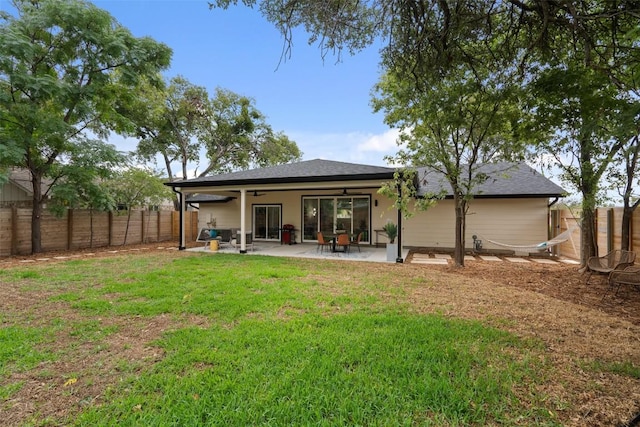 back of house featuring a patio area, a ceiling fan, a lawn, and a fenced backyard