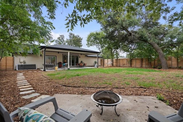 view of yard featuring a fenced backyard, a patio area, an outdoor fire pit, and a ceiling fan