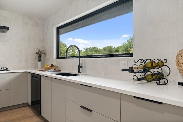 kitchen with backsplash, plenty of natural light, black dishwasher, and a sink