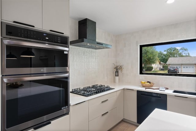 kitchen with tasteful backsplash, modern cabinets, wall chimney range hood, light countertops, and black appliances