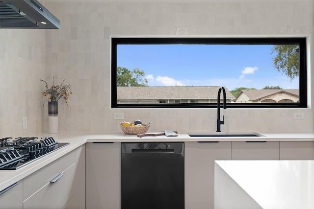 kitchen with backsplash, light countertops, a sink, and black appliances
