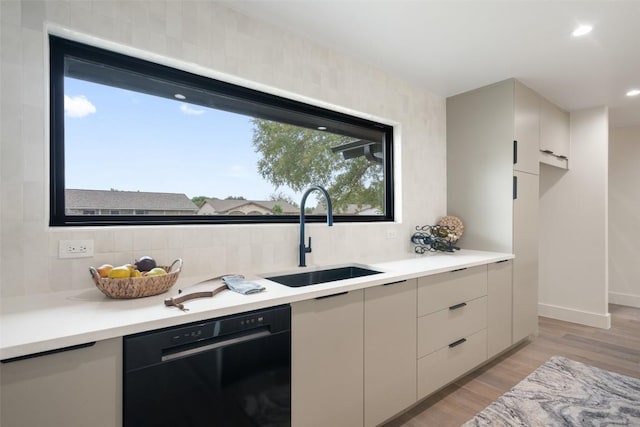kitchen with light countertops, a sink, tasteful backsplash, modern cabinets, and dishwasher