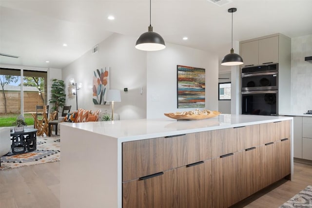 kitchen featuring modern cabinets, double oven, light wood-style floors, and light countertops