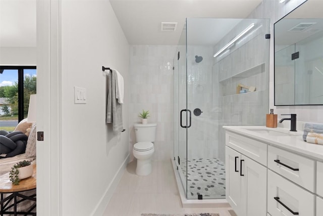 bathroom with toilet, a stall shower, baseboards, visible vents, and vanity