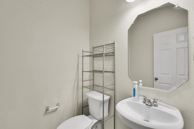 bathroom with toilet and a sink