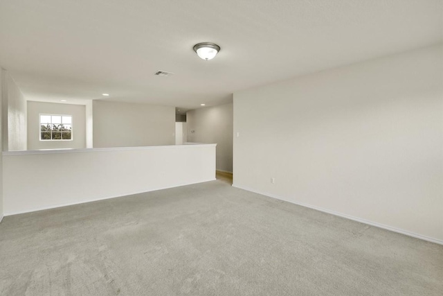 unfurnished room with recessed lighting, baseboards, and light colored carpet