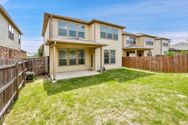 rear view of property with a yard, a patio area, and a fenced backyard