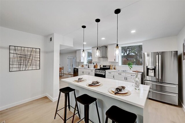 5000 Pack Saddle Pass, Austin, TX 78745 - kitchen featuring stainless steel appliances, a kitchen bar, light wood finished floors, white cabinets, and recessed lighting