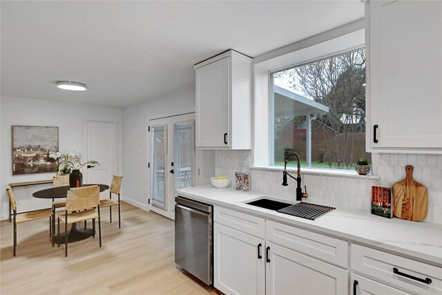 5000 Pack Saddle Pass, Austin, TX 78745 - kitchen featuring dishwasher, a sink, decorative backsplash, light wood-style floors, and white cabinets