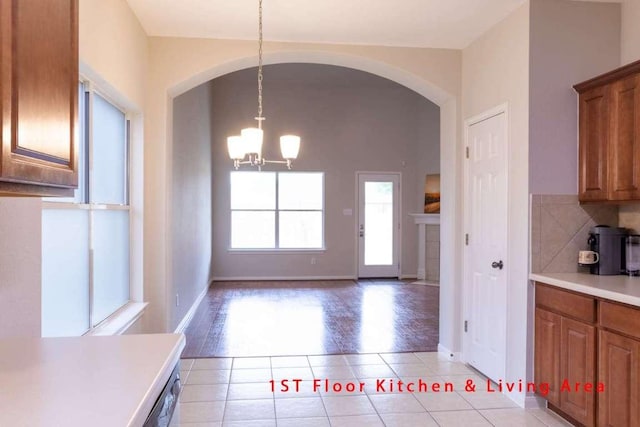 102 Buck Shot Ct, Bastrop, TX 78602 - unfurnished dining area featuring a chandelier, arched walkways, light tile patterned floors, and baseboards