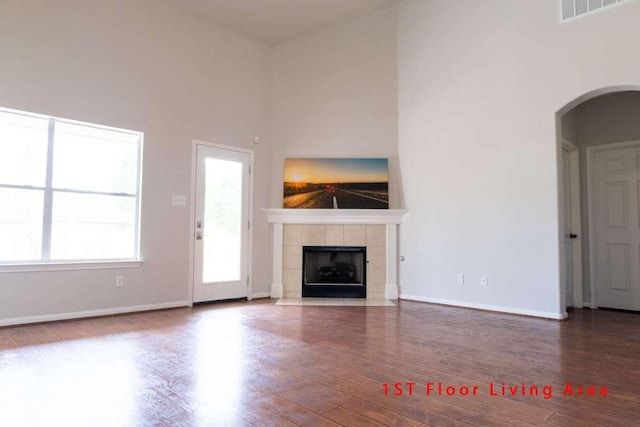 102 Buck Shot Ct, Bastrop, TX 78602 - unfurnished living room with arched walkways, wood finished floors, and a fireplace