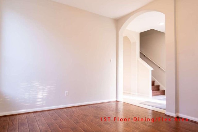102 Buck Shot Ct, Bastrop, TX 78602 - empty room with wood finished floors, arched walkways, baseboards, and stairway