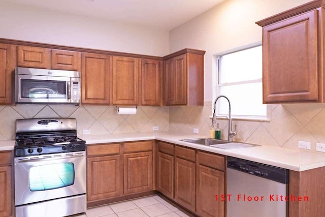 102 Buck Shot Ct, Bastrop, TX 78602 - kitchen with stainless steel appliances, a sink, brown cabinetry, light countertops, and decorative backsplash