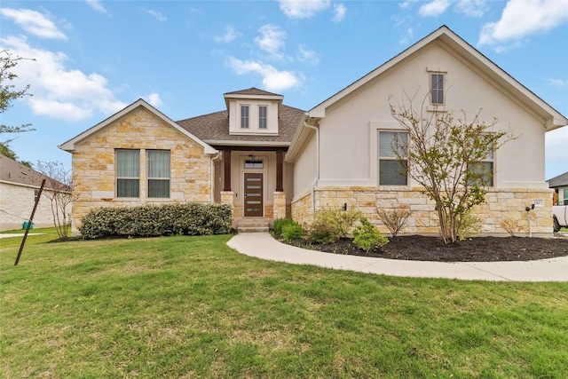 view of front of home featuring stone siding, roof with shingles, a front yard, and stucco siding