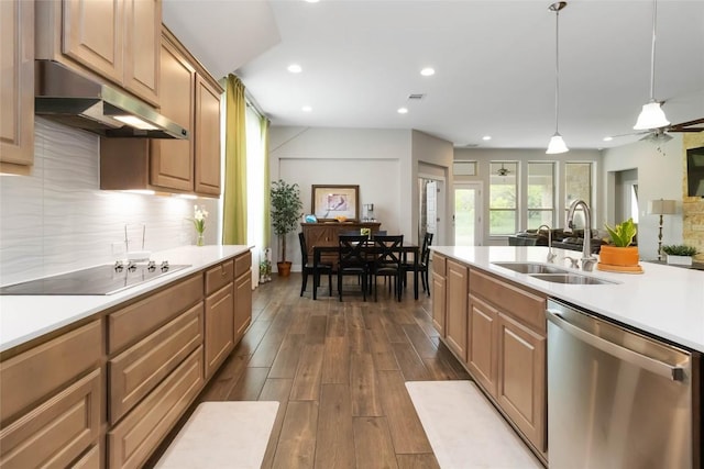 kitchen with under cabinet range hood, light countertops, stainless steel dishwasher, a sink, and black electric stovetop
