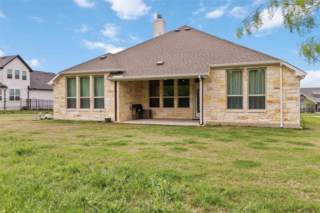 rear view of house with stone siding, a chimney, roof with shingles, and a patio