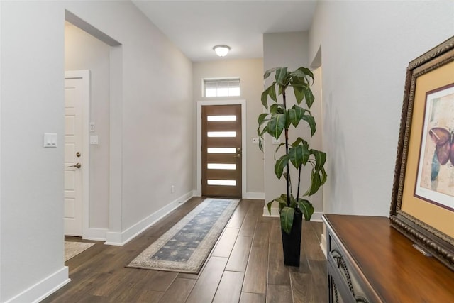 entrance foyer with dark wood-type flooring and baseboards