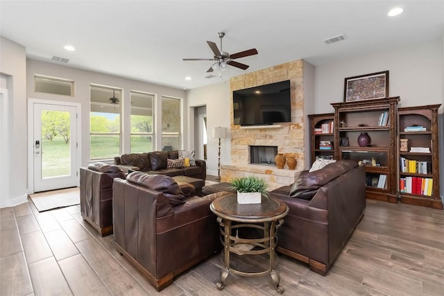 living room with recessed lighting, a stone fireplace, visible vents, and ceiling fan