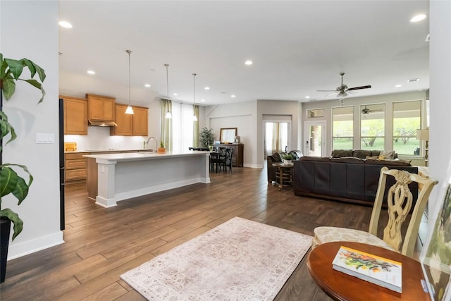 living room with dark wood-type flooring, a ceiling fan, baseboards, and recessed lighting