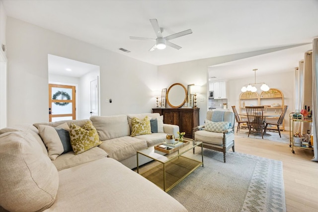 2602 Baxter Dr, Austin, TX 78745 - living room with light wood-style flooring, a ceiling fan, and a chandelier