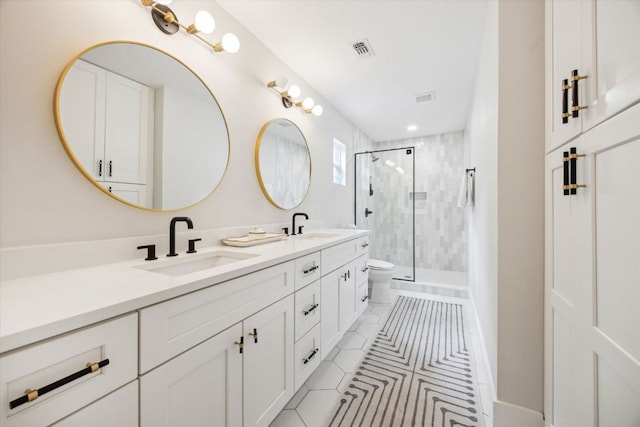 2602 Baxter Dr, Austin, TX 78745 - bathroom featuring double vanity, tile patterned flooring, a shower stall, and toilet
