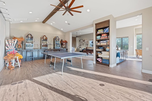 rec room featuring baseboards, a ceiling fan, wood finished floors, and vaulted ceiling with beams