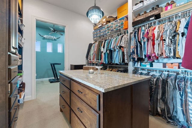 spacious closet featuring a ceiling fan and light colored carpet