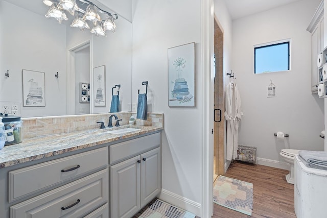 full bathroom featuring toilet, baseboards, decorative backsplash, wood finished floors, and vanity