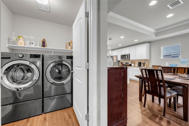 313 Brenham Pass, Georgetown, TX 78633 - clothes washing area with light wood finished floors, laundry area, visible vents, ornamental molding, and washer and dryer