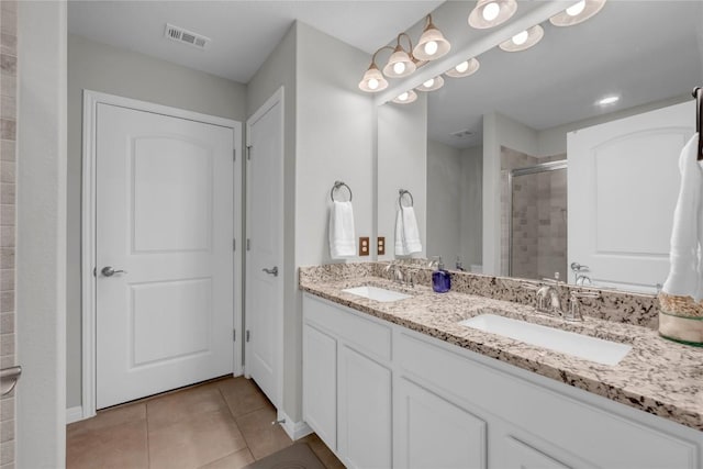 313 Brenham Pass, Georgetown, TX 78633 - bathroom featuring tile patterned floors, a sink, double vanity, and a stall shower