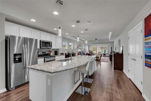 313 Brenham Pass, Georgetown, TX 78633 - kitchen featuring stainless steel appliances, a sink, visible vents, white cabinetry, and dark wood-type flooring