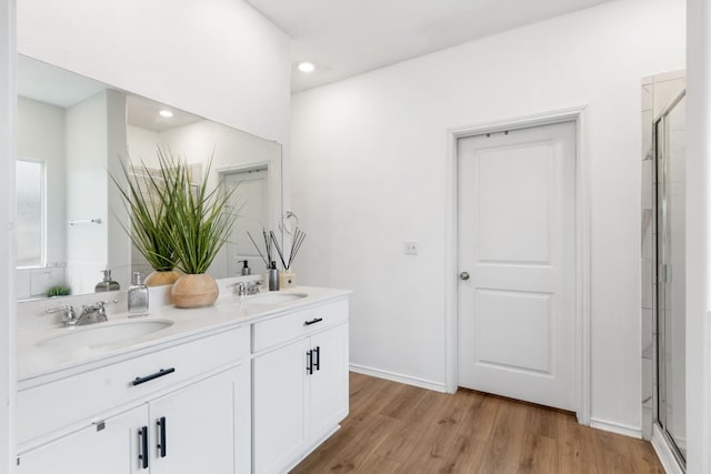 209 River Rise Rd, Kyle, TX 78640 - full bathroom featuring double vanity, a shower with door, wood finished floors, and recessed lighting