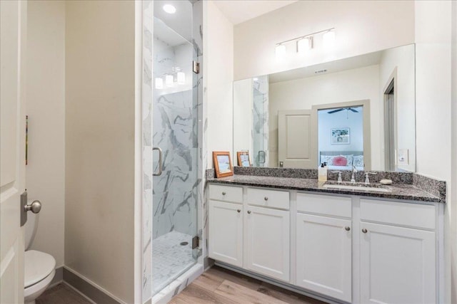 638 Oak Ln, Cottonwood Shores, TX 78657 - bathroom featuring a marble finish shower, vanity, toilet, and wood finished floors
