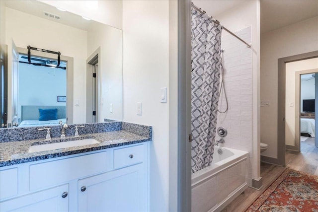 638 Oak Ln, Cottonwood Shores, TX 78657 - bathroom featuring connected bathroom, shower / bathtub combination with curtain, wood finished floors, and vanity