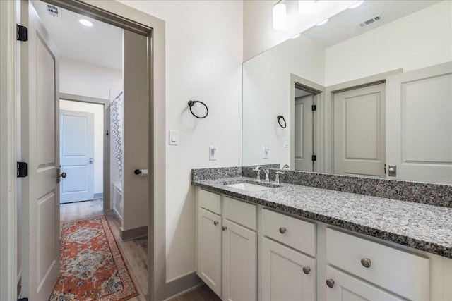 638 Oak Ln, Cottonwood Shores, TX 78657 - bathroom with vanity, baseboards, wood finished floors, and shower / tub combo with curtain
