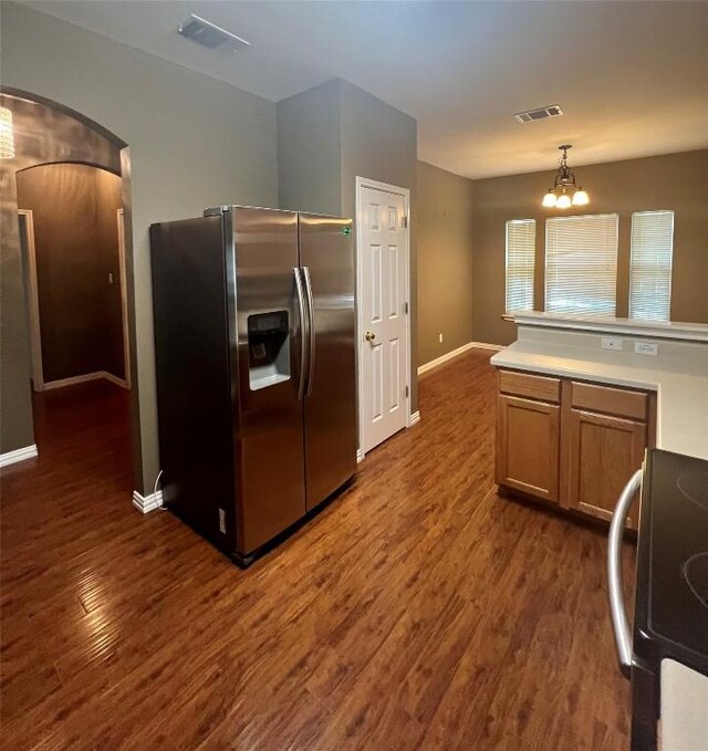 kitchen featuring arched walkways, black electric range oven, stainless steel refrigerator with ice dispenser, and visible vents