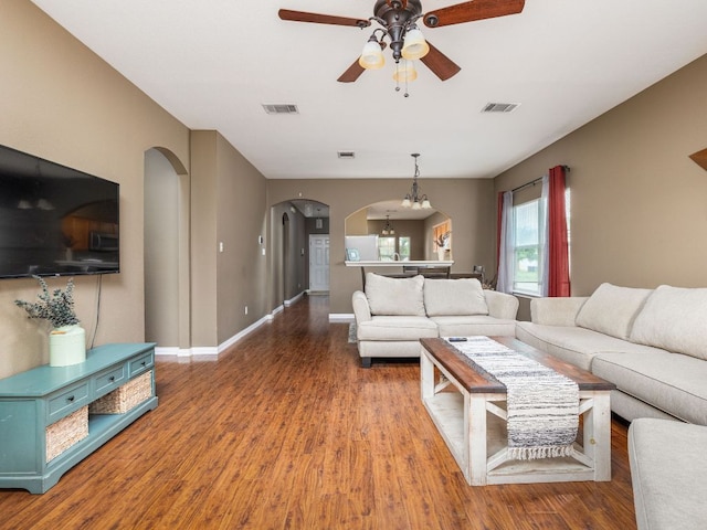 116 Brown St, Hutto, TX 78634 - living room featuring arched walkways, a ceiling fan, wood finished floors, baseboards, and a chandelier
