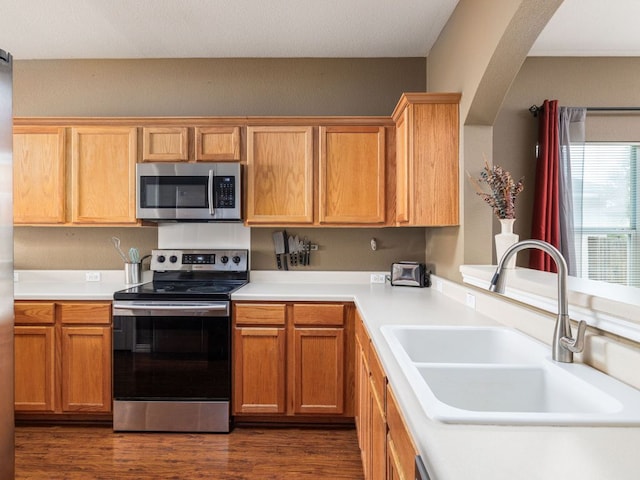 116 Brown St, Hutto, TX 78634 - kitchen featuring appliances with stainless steel finishes, a sink, dark wood finished floors, and light countertops