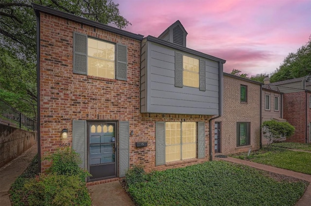 view of front of home featuring fence and brick siding