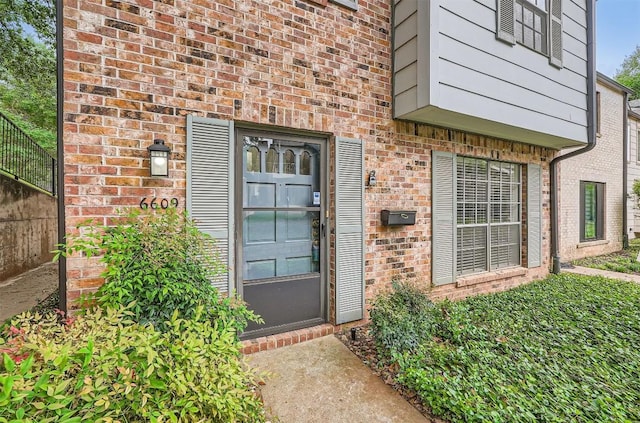 view of exterior entry with brick siding