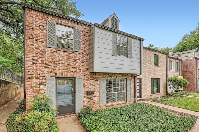 view of front of home featuring brick siding, fence, and a front yard