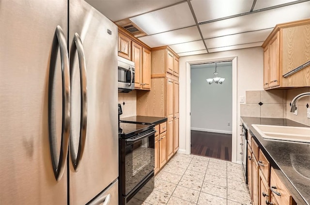 kitchen featuring stainless steel appliances, a sink, visible vents, a chandelier, and decorative backsplash