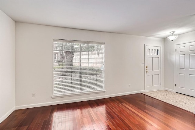 foyer entrance featuring baseboards and hardwood / wood-style floors
