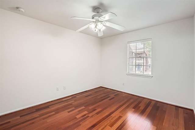 empty room featuring wood finished floors, a ceiling fan, and baseboards