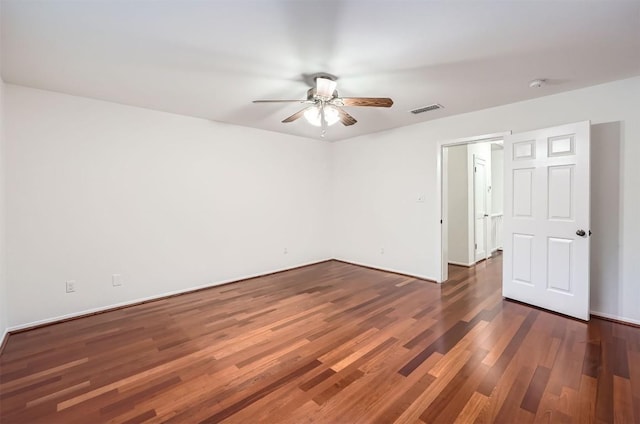 unfurnished room featuring wood finished floors, visible vents, a ceiling fan, and baseboards