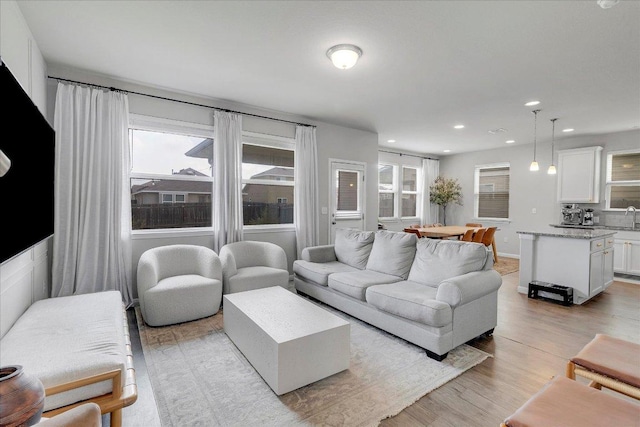 living area featuring light wood finished floors and recessed lighting