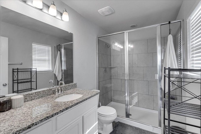 full bathroom featuring a wealth of natural light, toilet, vanity, and a stall shower