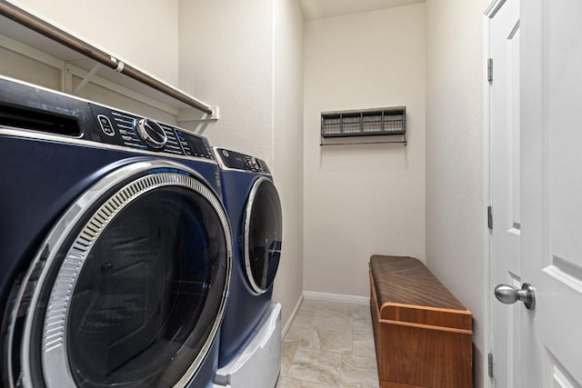 laundry area featuring separate washer and dryer, baseboards, marble finish floor, and laundry area