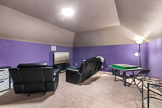 home theater with carpet flooring, a textured ceiling, vaulted ceiling, visible vents, and a textured wall